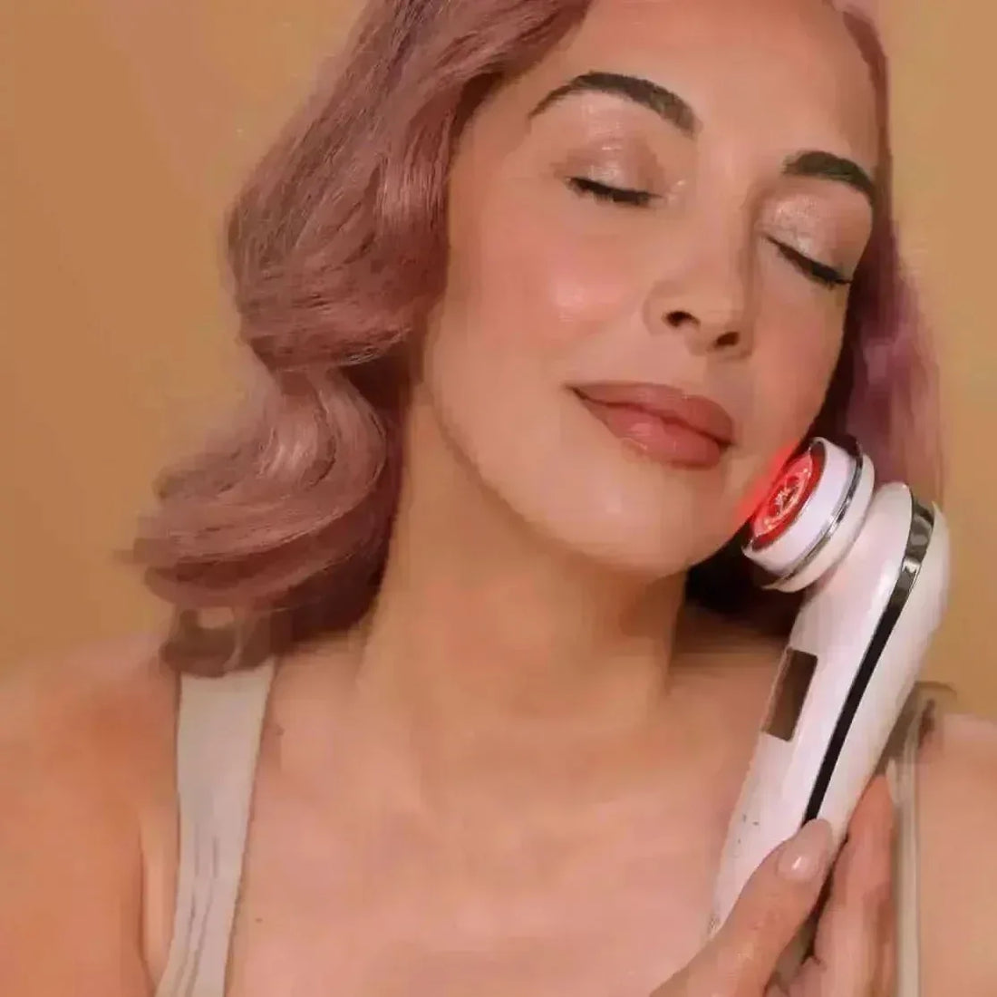 Woman using the EvenSkyn Lumo+ radiofrequency handset along her jawline